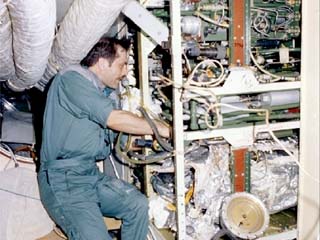 Mir-24 flight engineer Pavel Vinogradov repairs hardware in Mir Space Station. 